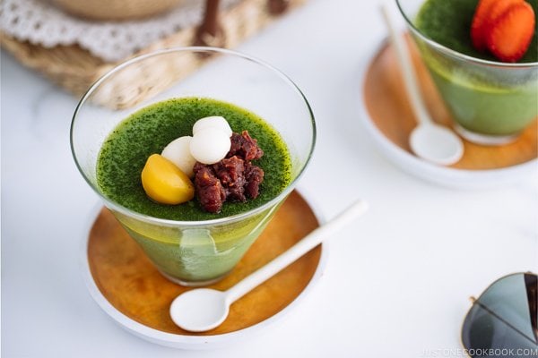 Matcha Vegan Panna Cotta served in a glass bowl, topped with mochi, red bean paste, and candied chestnut.