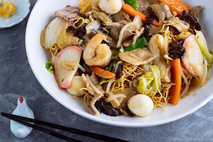 A plate containing Chinese-style crispy noodles with saucy seafood and vegetables.