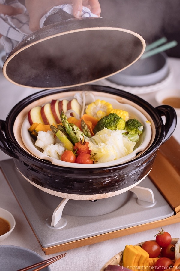 Steamed vegetables in a Japanese earthenware pot, donabe. Steam coming off from the pot.