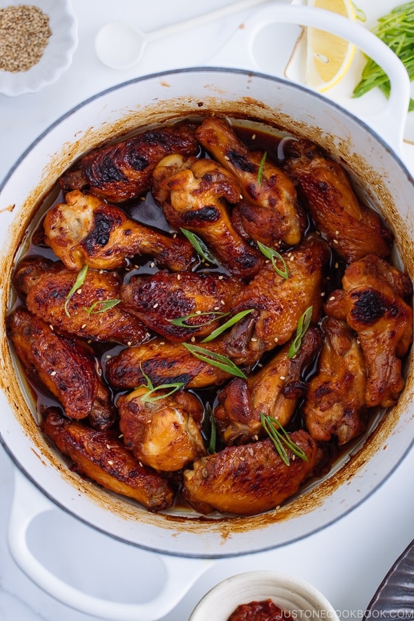 Teriyaki wings in a white Le Creuset pot.