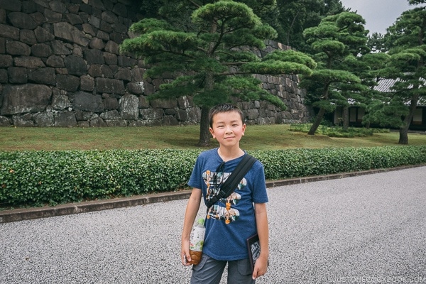 A boy standing in front of a tree