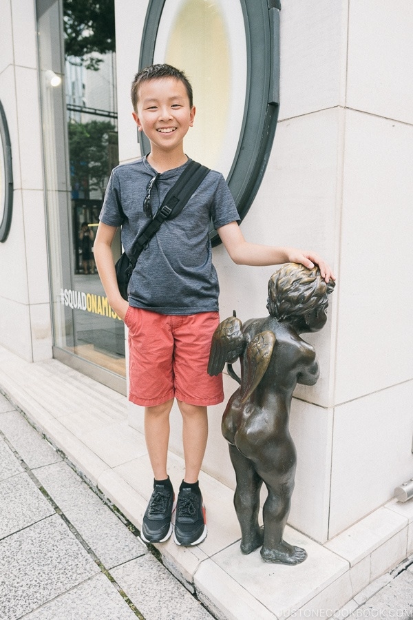 Just One Cookbook child standing next to cupid statue in front of Tenshodo Ginza - Tokyo Ginza Travel Guide | www.justonecookbook.com