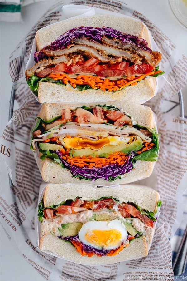 A basket containing 3 kinds of thick colorful Japanese sandwich, Wanpaku Sandiwch (Sando).