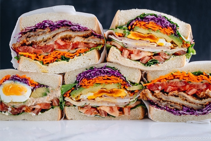 Colorful thick Japanese sandwich, Wanpaku Sandiwch (Sando), shows the filling and piles up on the table.