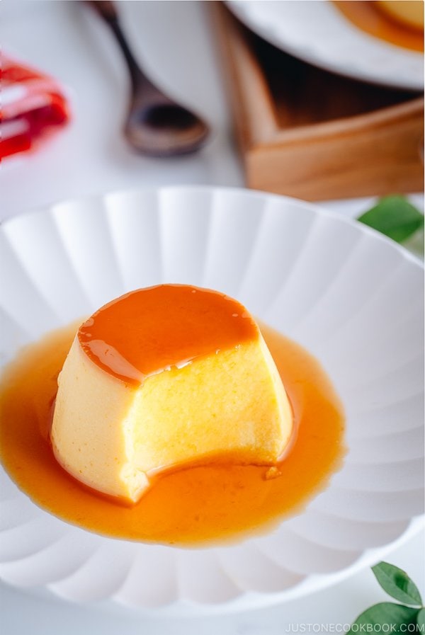 A white plate containing Kabocha-flavored Flan with caramel sauce on top.