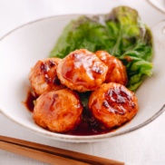 A white dish containing Chicken Meatballs with Sweet and Sour Sauce.