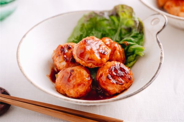 A white dish containing Chicken Meatballs with Sweet and Sour Sauce.