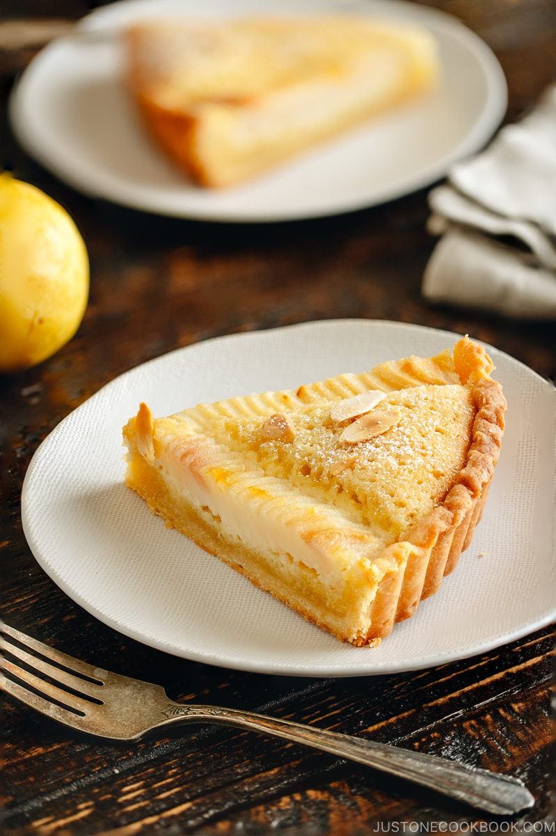 A slice of Pear and Almond Tart (Pear Frangipane Tart) on a plate.