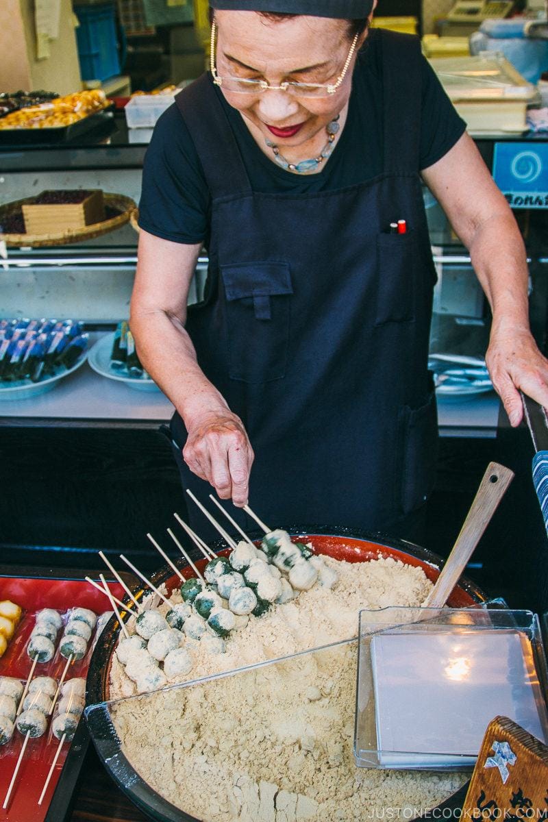 lady making odango dipped in kinako on Nakamise Dori - Tokyo Asakusa Travel Guide | www.justonecookbook.com