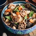 A blue Japanese bowl containing Nishime, simmered vegetables and chicken.