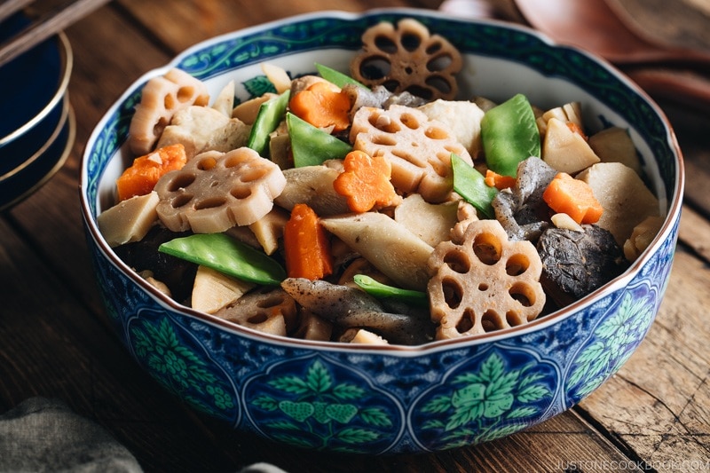 A blue Japanese bowl containing Nishime, simmered vegetables and chicken.