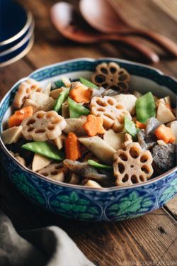 A blue Japanese bowl containing Nishime, simmered vegetables and chicken.