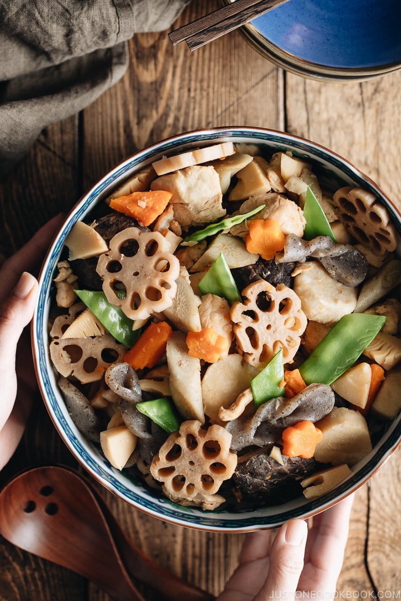 A blue Japanese bowl containing Nishime, simmered vegetables and chicken.