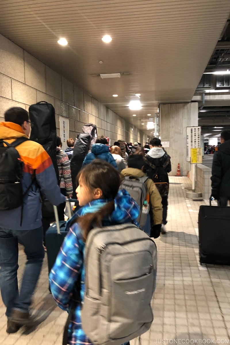 people walking towards waiting buses at Tokyo metropolitan government building - Hakuba Travel and Ski Guide | www.justonecookbook.com