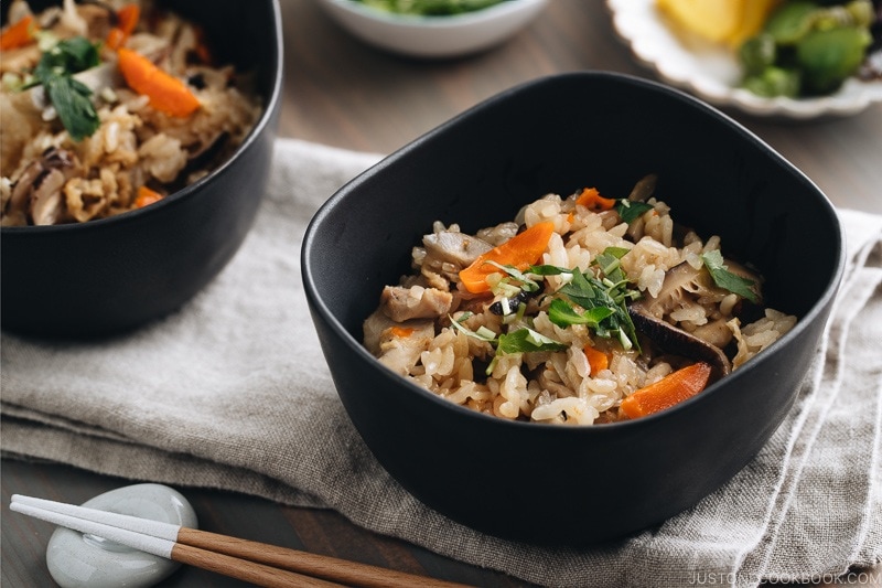 Black ceramic bowls containing Japanese Mixed Rice (Takikomi Gohan).