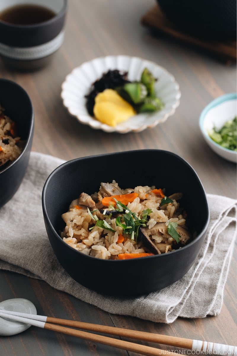 Black ceramic bowls containing Japanese Mixed Rice (Takikomi Gohan).