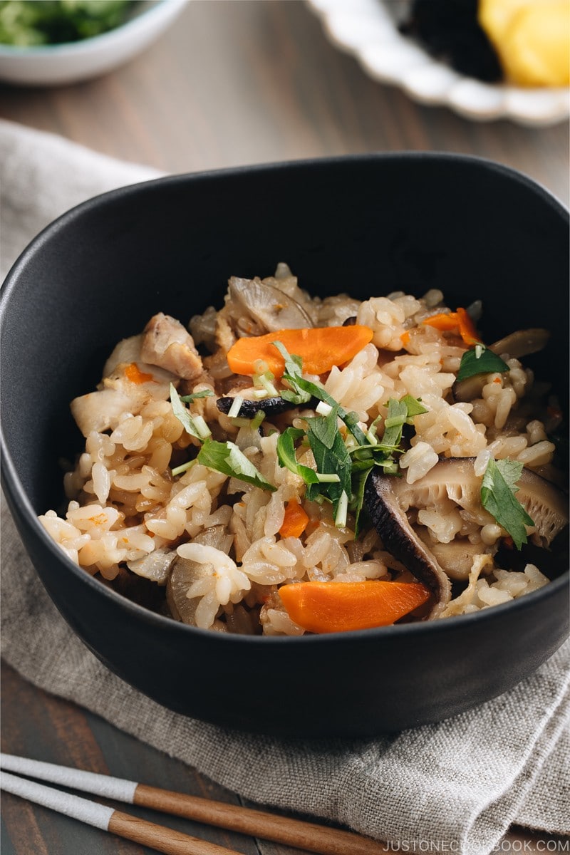 Black ceramic bowls containing Japanese Mixed Rice (Takikomi Gohan).