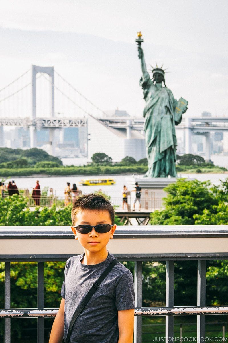 child in front of Odaiba Statue of Liberty and Rainbow Bridge - Tokyo Odaiba Travel Guide | www.justonecookbook.com