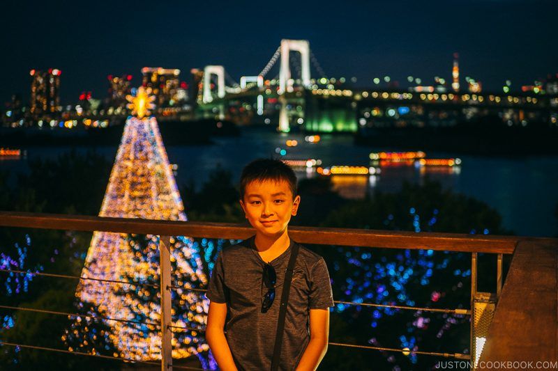 child in Odaiba in front of Rainbow Bridge at night - Tokyo Odaiba Travel Guide | www.justonecookbook.com