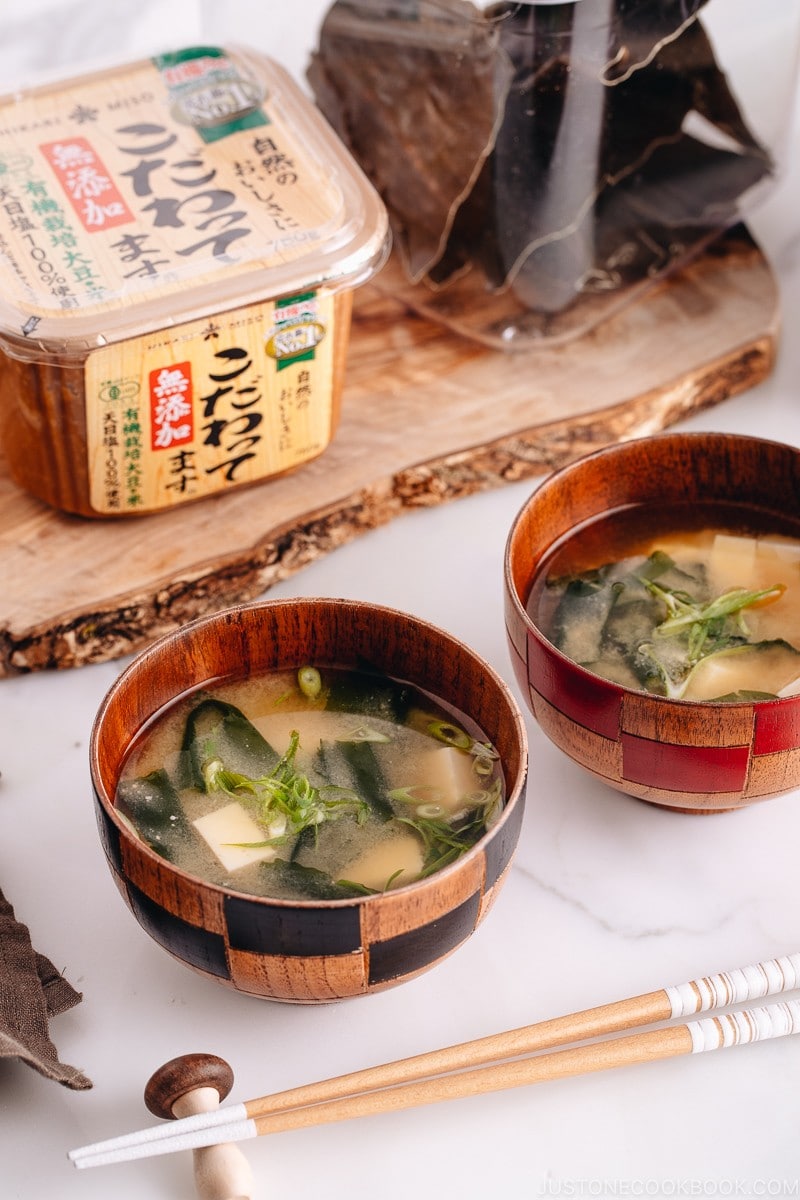 Japanese wooden bowls containing vegan miso soup with tofu and seaweed.