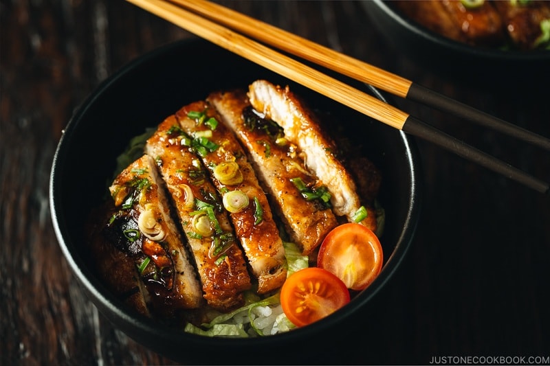 teriyaki pork in a black bowl