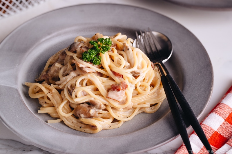 Creamy Mushroom and Bacon Pasta on a grey plate.