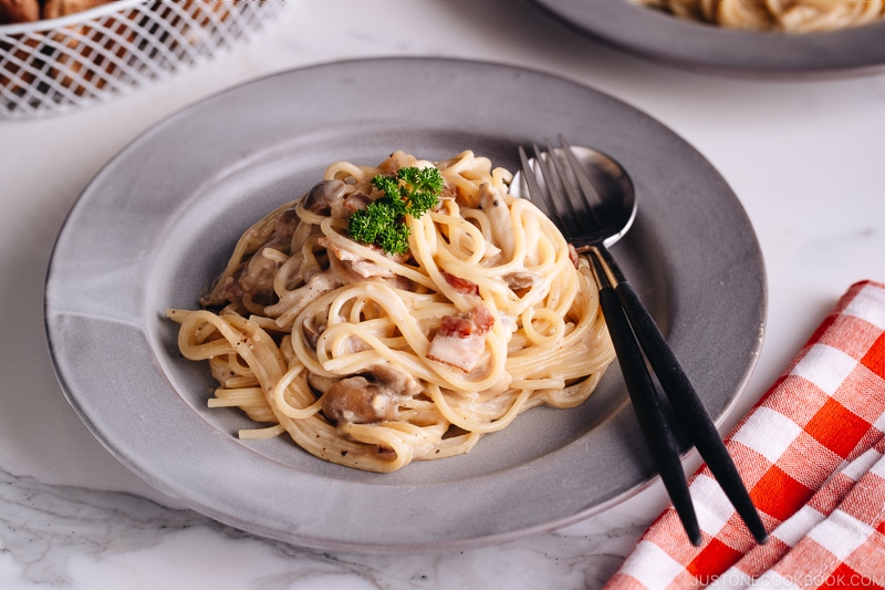 Creamy Mushroom and Bacon Pasta on a grey plate.