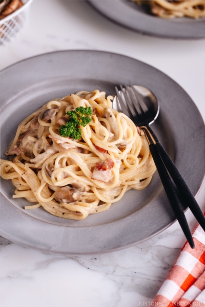 Creamy Mushroom and Bacon Pasta on a grey plate.