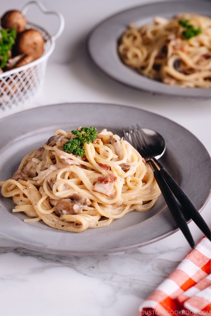 Creamy Mushroom and Bacon Pasta on a grey plate.