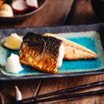 Grilled mackerel (saba shioyaki) on a Japanese style plate, served with miso soup, rice and pickles.