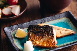 Grilled mackerel (saba shioyaki) on a Japanese style plate, served with miso soup, rice and pickles.