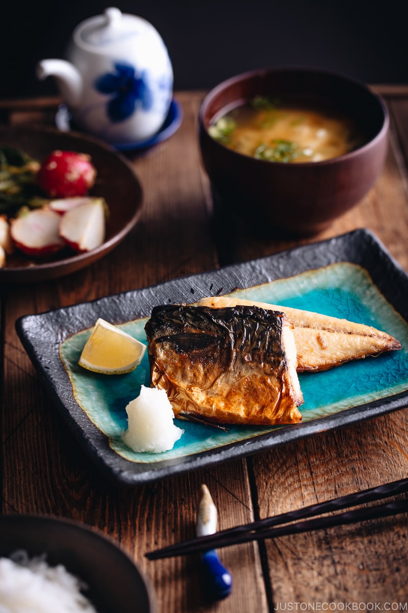 Grilled mackerel (saba shioyaki) on a Japanese style plate, served with miso soup, rice and pickles.