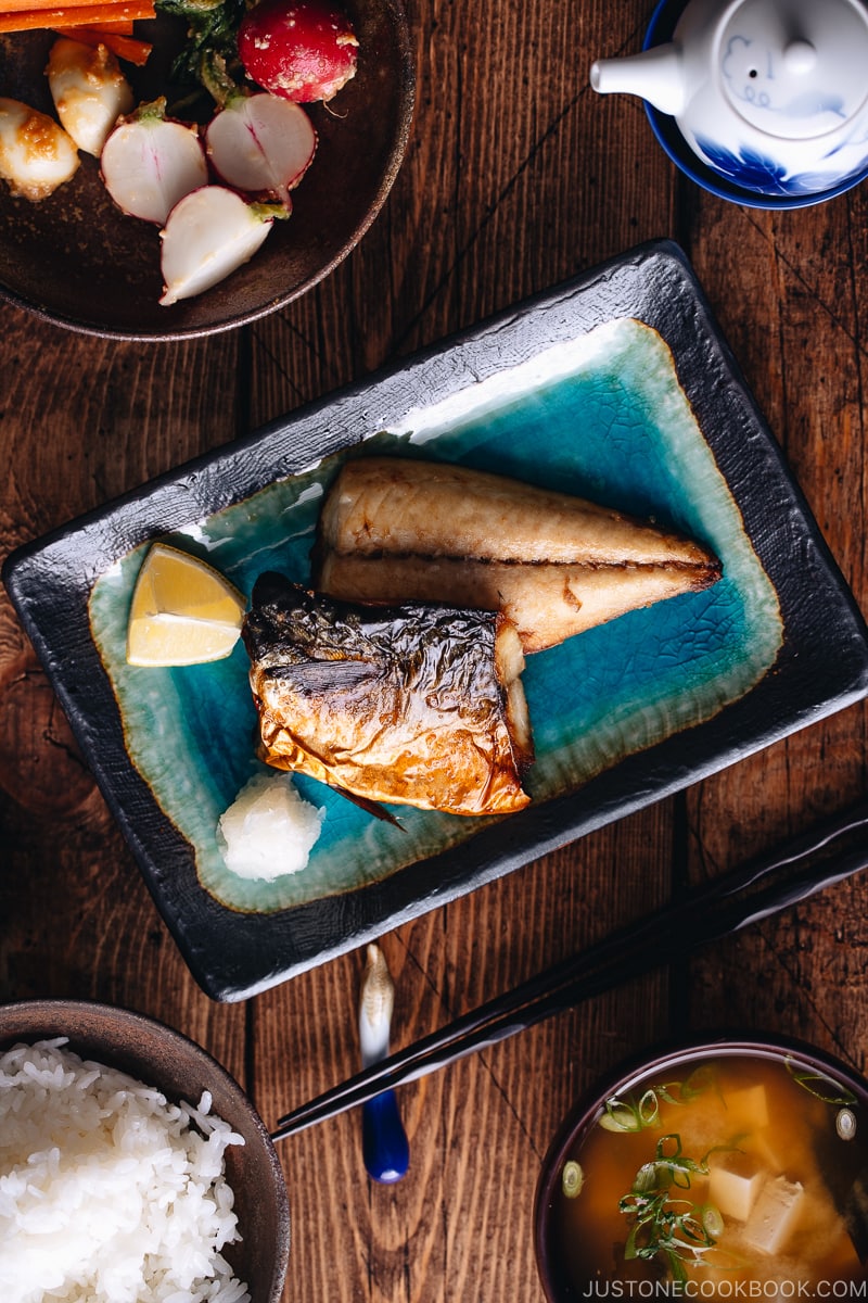 Grilled mackerel (saba shioyaki) on a Japanese style plate, served with miso soup, rice and pickles.