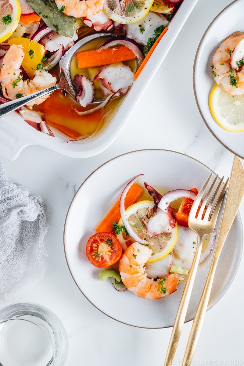 Seafood salad with vinaigrette in the white baking dish.