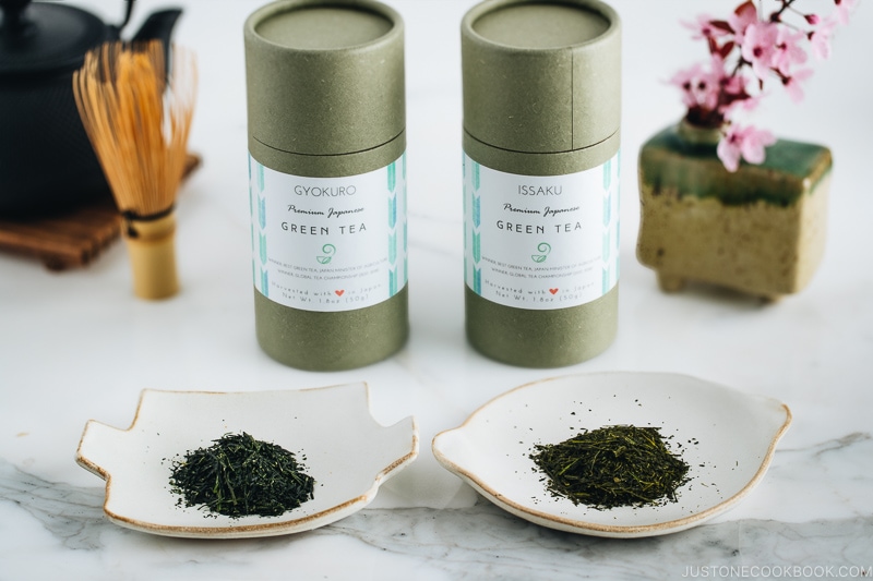 Two types of Japanese green tea and their containers along with tea pot.