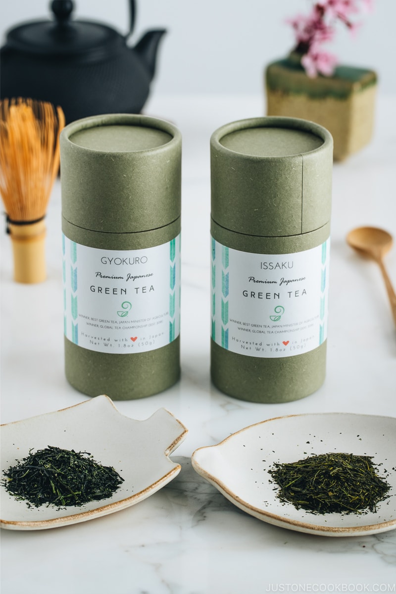 Two types of Japanese green tea and their containers along with tea pot.