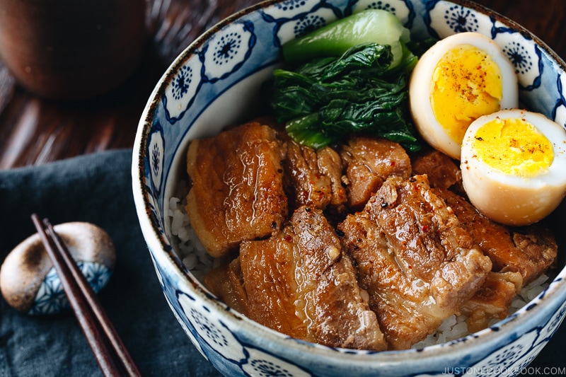 Pressure cooker kakuni (Instant Pot Japanese Pork Belly) served over rice along with eggs and vegetables in a donburi bowl.