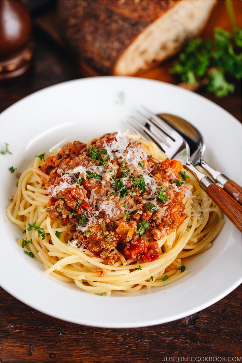 Spaghetti Bolognese on a white plate next to the Instant Pot.