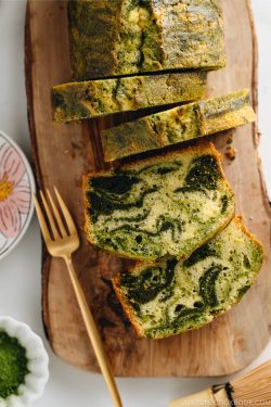 A few slices of matcha marble pound cake served on a wooden board.