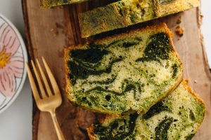 A few slices of matcha marble pound cake served on a wooden board.