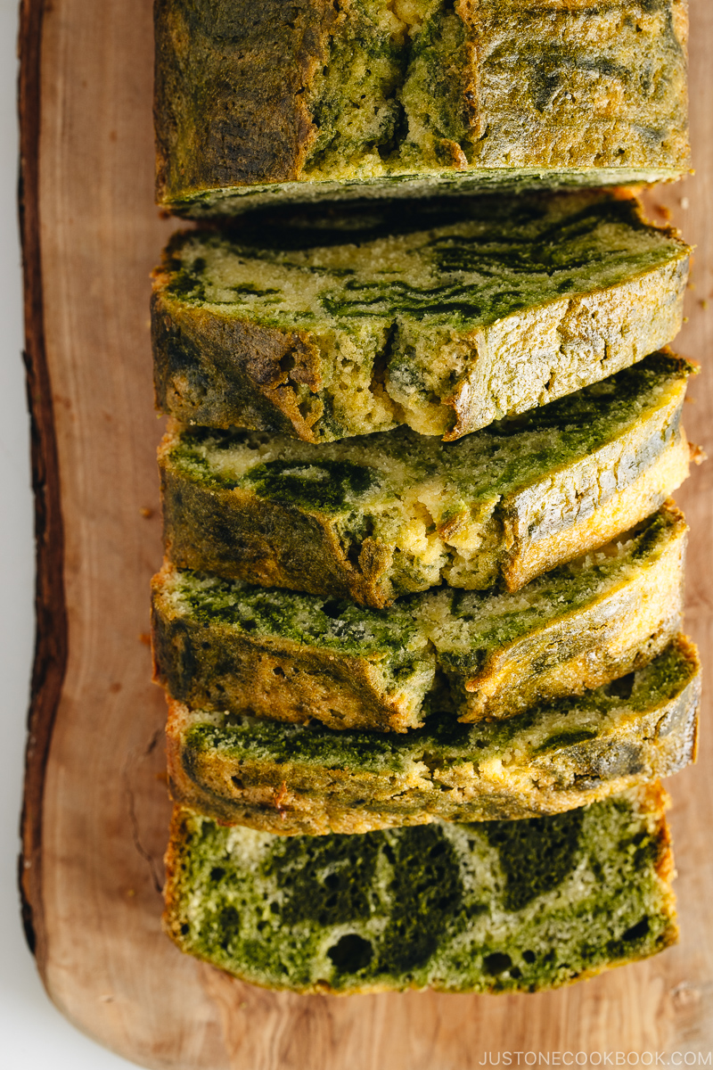 A few slices of matcha marble pound cake served on a wooden board.