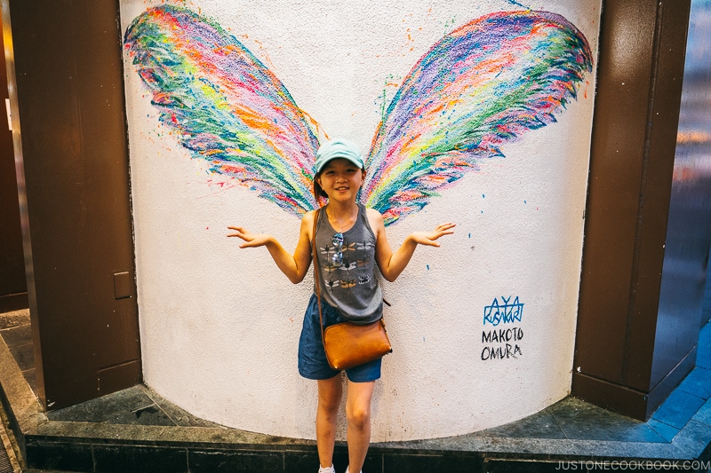 girl standing in front of wings painting - Osaka Guide: Dotonbori and Namba | www.justonecookbook.com