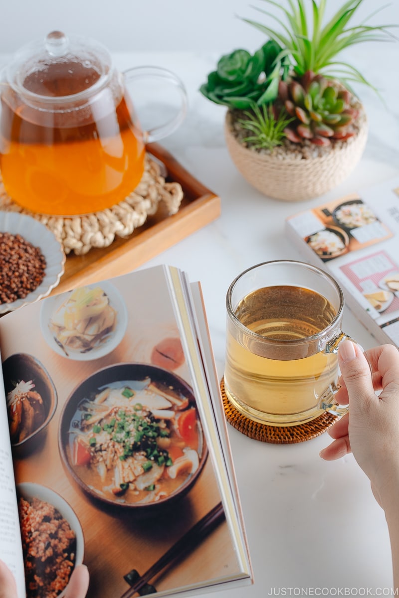 Hot buckwheat tea (sobacha) served in a glass cup.