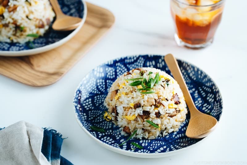 Chashu fried rice on the blue plate, garnish with chopped green onions.