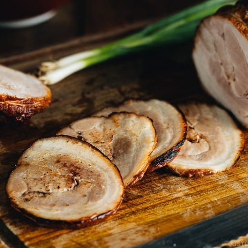 Thin slices of Chashu on the cutting board.