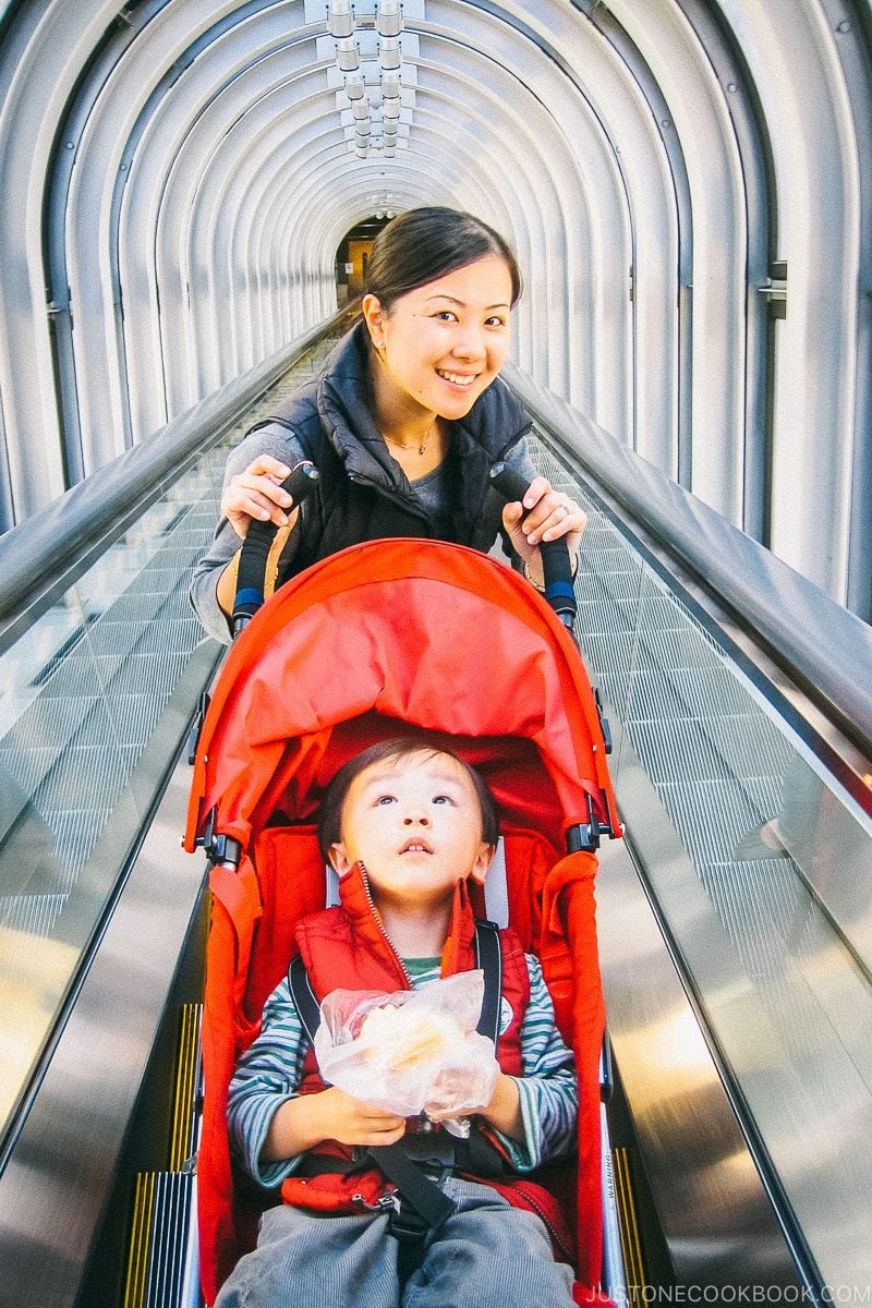 Nami with child in s stroller going up escalator in Sky Building - Osaka Guide: Umeda | www.justonecookbook.com