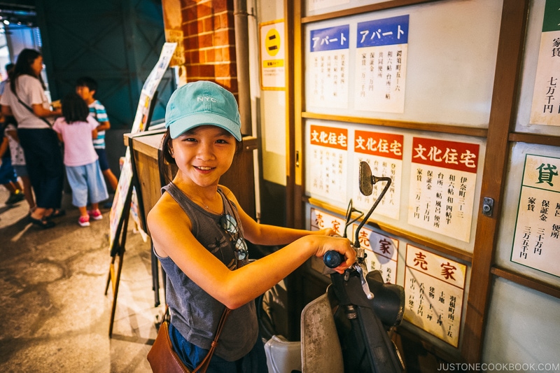 child next to 1960s moped at Naniwa Kushinbo Yokocho - Osaka Guide: Tempozan Harbor Village | www.justonecookbook.com