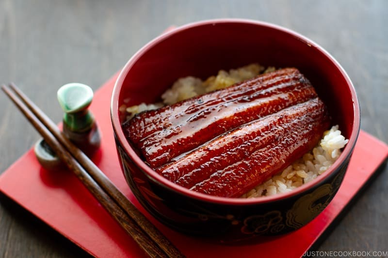 A lacquer bowl containing Unagi (Eel) over steamed rice.