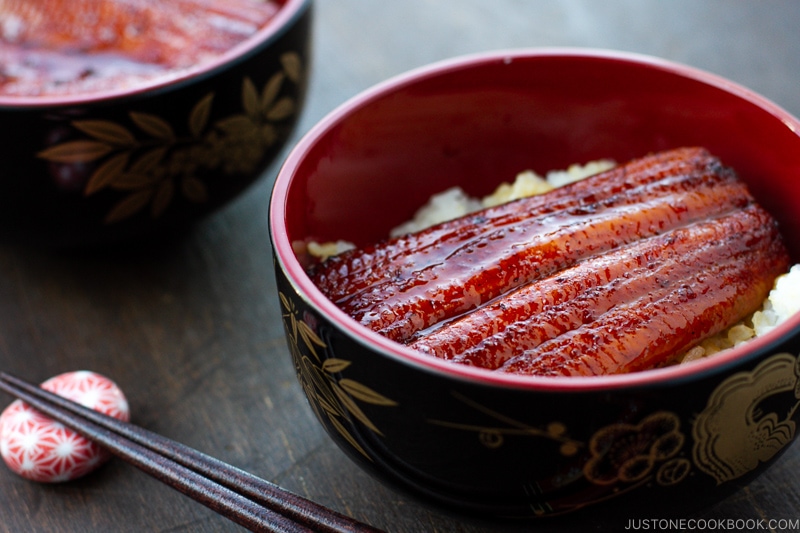 A lacquer bowl containing Unagi (Eel) over steamed rice.