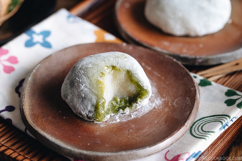 Green tea mochi showing inside white bean paste.